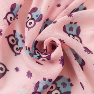 Close-up of soft pink cotton scarf with cartoon owl patterns and lightweight fabric texture