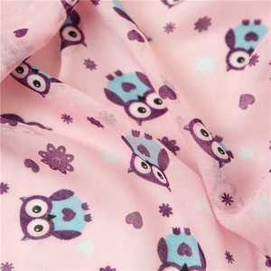 Close-up of soft pink linen cotton fabric with cute owl print and star patterns