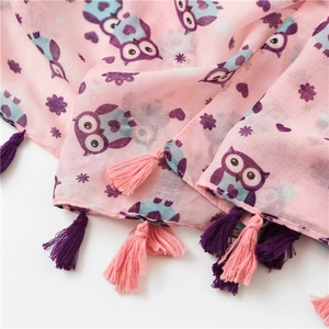 Close-up of pink linen scarf with purple owl prints and matching decorative tassels