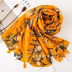 Sciarpa leggera in cotone giallo con stampe floreali bianche e nere e bordi con frange