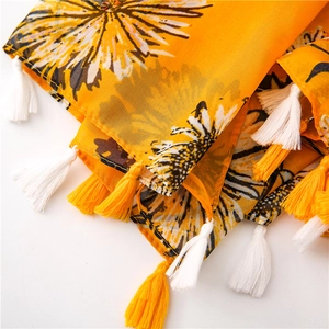 Vista dettagliata della sciarpa di cotone gialla con stampa girasole e nappe a frangia