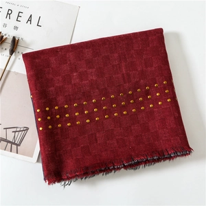Close-up of burgundy cotton linen scarf with gold rivets and raw fringe details