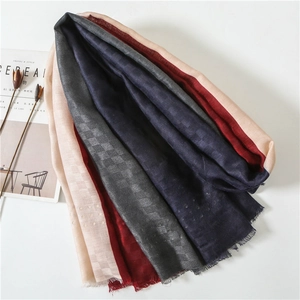 Detail of color-block scarf with jacquard patterns and soft raw edge fringe design