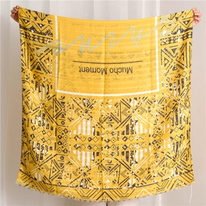Detail eines gelben Baumwollschals mit schwarzen Boho-Mustern und offenen Fransen