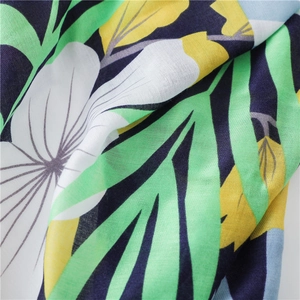 Detailed macro view of cotton linen scarf with tropical white floral and green leaf print