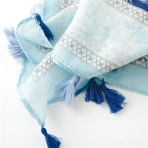 Nahaufnahme eines hellblauen Baumwollschals mit Paisleymuster und blauen Quasten am Rand
