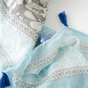 Detail eines böhmischen Strandtuches mit Cashew-Print und hellblauen Fransenakzenten