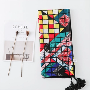 Ethnic retro rainbow grid scarf with bold geometric prints and black tassels on white backdrop