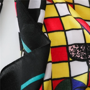 Detail of colorful geometric pattern scarf showing vibrant hues and light woven fabric