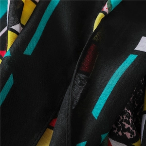 Macro detail of colorful geometric and leopard print patterns on woven ethnic style scarf
