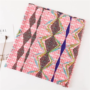 Detail of pink geometric printed silk scarf showing soft fringe edges and pop art pattern