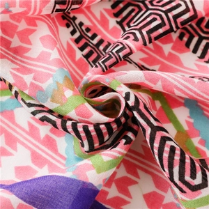 Detail of vibrant pink scarf featuring geometric star patterns and frayed edge texture