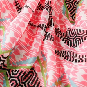 Close-up of pink geometric pattern fabric with tribal motifs and frayed edge detail