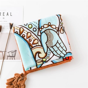 Détail d'un châle en coton et lin bleu clair avec imprimé ethnique et pompons