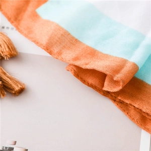 Détail de l'écharpe en coton et lin à rayures orange et menthe avec bords à franges