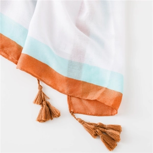 Détail du tissu en coton et lin avec rayures bleues et glands à franges marron