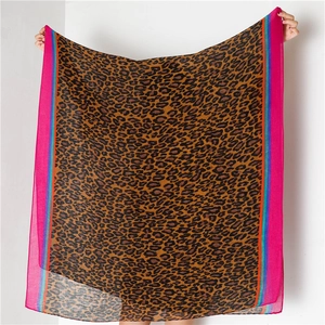Close-up of leopard print scarf with pink borders and colorful stripe detailing