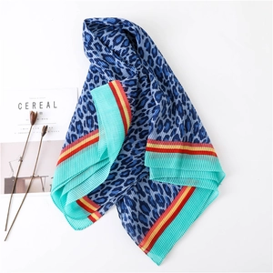 Detail of leopard print pleated scarf with geometric borders and fine texture