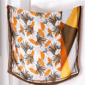 Detail of thin shawl scarf with tropical leaf print and geometric color blocks