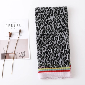 Close-up of pleated leopard print scarf with colorful stripe edges and fine textures