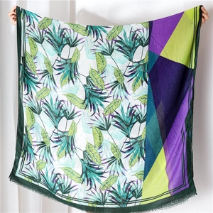 Detail of thin tropical print shawl with fringed edges and geometric color blocks
