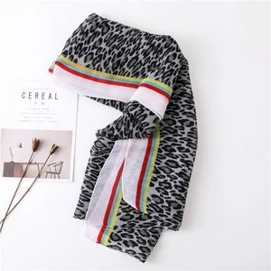 Detail of pleated leopard print scarf with colorful striped edges and light texture