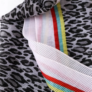 Macro shot of pleated scarf fabric with leopard print and vibrant colorful stripes