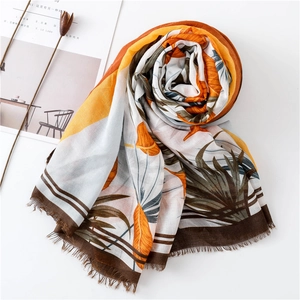 Detail of tropical plant print scarf with fringed edges and soft breathable fabric