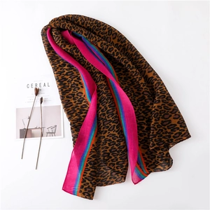 Detail of pleated leopard print scarf with vibrant fuchsia and emerald green edges