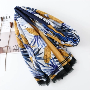 Detail of tropical palm leaf print scarf with soft frayed edges on white background