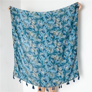 Detail of teal leaf print cotton scarf with matching fringe tassels for beach sun protection