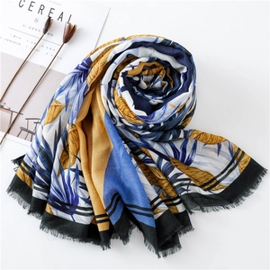 Macro detail of tropical palm print scarf featuring delicate frayed fringe edges
