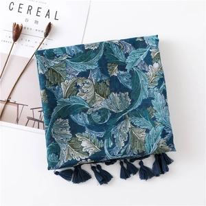 Detail of bohemian paisley linen scarf with blue tassels and elegant leaf pattern
