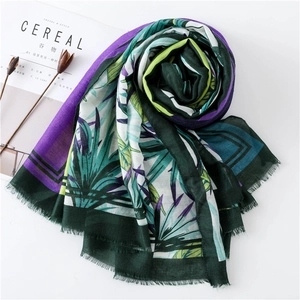Detail of printed summer scarf with tropical leaf pattern and delicate frayed edges