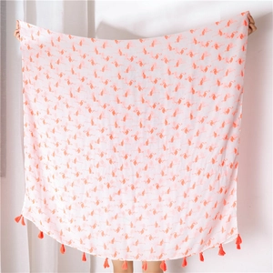 Close-up of pink flamingo print on white cotton linen shawl with orange tassels