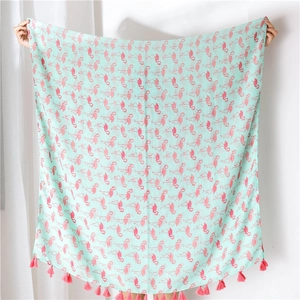 Detail of mint green pashmina scarf with pink flamingo prints and fringed edges