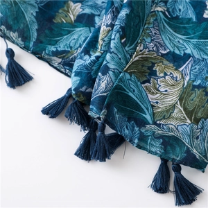 Detail of artistic leaf print scarf with navy tassels and high-quality cotton linen texture