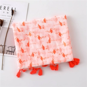 Detail of light pink cotton scarf with orange flamingo prints and handmade tassels