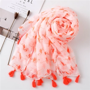 Detail of light pink summer scarf with orange flamingo print and vibrant fringe tassels