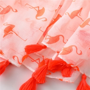 Close-up of pink cotton linen scarf featuring flamingo print and tassel fringe detail