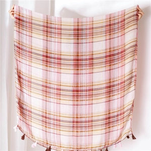 Detail of pink and beige plaid shawl featuring long cotton fringe tassels at the edge