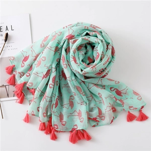 Detail of mint green scarf featuring pink flamingo prints and long tassel fringe edges