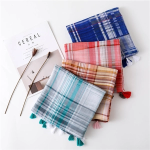 Detail of plaid tasseled scarves in four colors with soft cotton linen texture