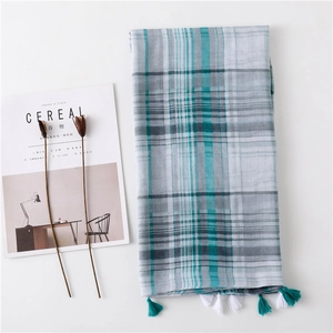 Detail of teal plaid scarf with tassel fringe edges and soft cotton linen texture