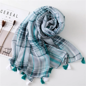 Flat lay of plaid scarf with tassels, styled with a magazine for a lifestyle aesthetic