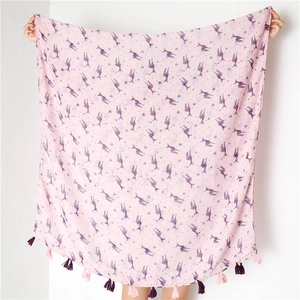 Detail of light pink scarf with purple deer print and decorative fringe tassels