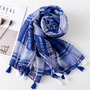 Detail of blue and white checkered scarf featuring soft cotton-linen fringe tassels