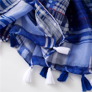 Detail of blue and white plaid scarf fabric with elegant soft fringe tassels