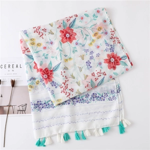 Détail d'une écharpe bohème à fleurs avec imprimé coloré et franges sur fond blanc