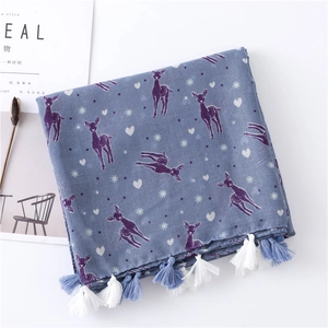 Detail of blue scarf with purple deer prints and white heart patterns with fringe trim